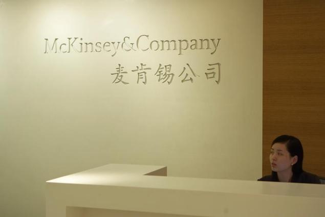 --FILE--A Chinese employee is seen at the front desk of McKinsey & Company in Shanghai, China, 29 October 2007. Global management consulting firm McKinsey has opened its Industrial Internet of Things (IIoT) hub in China to help local firms drive digital transformation, the company announced Tuesday. The biggest challenge for IIoT application is \\\"the last mile,\\\" especially the large-scale integration of information technology and operational technology, said Karel Eloot, a senior partner at McKinsey. (Imaginechina via AP Images)