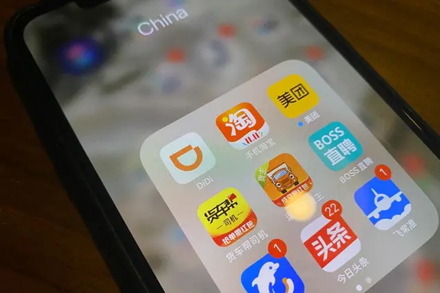 The ride-hailing app Didi is seen near other Chinese apps on a phone in Beijing on Monday, July 5, 2021. Chinese regulators have clamped down on the countryâ€™s largest ride-hailing app, Didi Global Inc., days after its shares began trading in New York. Authorities told Didi to stop new registrations and ordered its app removed from Chinaâ€™s app stores pending a cybersecurity review. (AP Photo/Ng Han Guan)