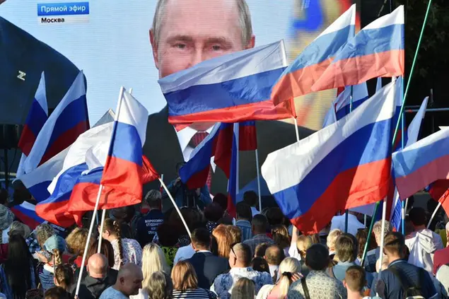 People watch on a large screen, as Russian President Vladimir Putin delivers his speech after a ceremony to sign the treaties for four regions of Ukraine to join Russia in the Moscow's Kremlin, during a meeting in Sevastopol, Crimea, Friday, Sept. 30, 2022. The signing of the treaties making the four regions part of Russia follows the completion of the Kremlin-orchestrated \\\"referendums.\\\" (AP Photo)