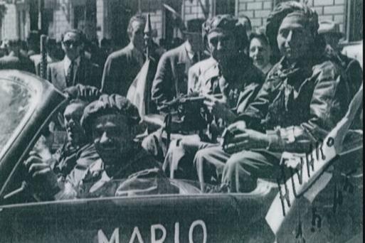 Torino, 6 maggio 1945, sfilata della Liberazione. Tra i passeggeri della jeep si riconosce il partigiano tedesco Heinz Brauwers (fotografia proveniente dall'archivio di Hans Brauwers, depositata presso ISTORETO)