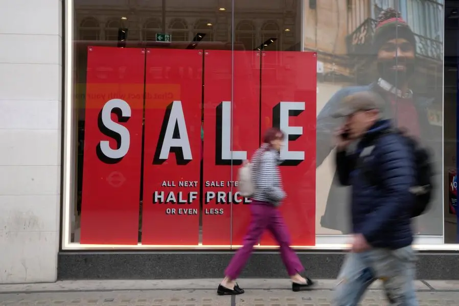 Shoppers pass a sale sign on a shop window in Oxford Street in London, Wednesday, April 13, 2022. British consumer prices rose at their fastest pace in 30 years last month, fueled by soaring prices for household energy and motor fuels. The Office of National Statistics reported on Wednesday that inflation accelerated to 7% in the 12 months through March. (AP Photo/Kirsty Wigglesworth)