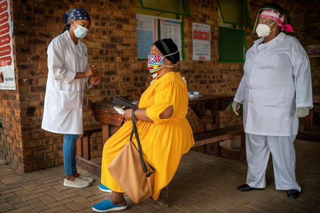 A South African woman is briefed before taking a COVID-19 test at the Ndlovu clinic in Groblersdal , 200 kms north-east of Johannesburg, Thursday Feb. 11, 2021. African countries without the coronavirus variant dominant in South Africa should go ahead and use the AstraZeneca COVID-19 vaccine, the Africa Centers for Disease Control and Prevention said Thursday, while the World Health Organization suggested the vaccine even for countries with the variant circulating widely.(AP Photo/Jerome Delay)