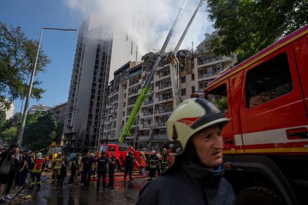 Firefighters work at the scene of a residential building following explosions, in Kyiv, Ukraine, Sunday, June 26, 2022. Several explosions rocked the west of the Ukrainian capital in the early hours of Sunday morning, with at least two residential buildings struck, according to Kyiv mayor Vitali Klitschko. (AP Photo/Nariman El-Mofty)