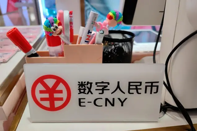 An E-CNY payment sign is put up on a desk in a store in the Luohu District in Shenzhen city, south China's Guangdong province, 11 October 2020. The Shenzhen municipal government announced a giveaway of ten million renminbi ($1.5 million) in central bank digital currency (CBDC). Fifty thousand people would receive the gifted money on a lottery basis in amounts of 200 yuan as part of the digital yuan tests and the trial was in the Luohu District. In accordance with the trial, about 3389 shops including restaurants and retail stores had updated and equiped system allowing eCNY payment in the Luohu District. As of 8p.m. on 11th October 2020, over 1.91million people participated in the lottery winning. (Imaginechina via AP Images)