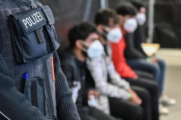 05 November 2021, Brandenburg, Frankfurt (Oder): Migrants sit in the newly established central processing centre of the Federal Police and the Federal Office for Migration and Refugees (BAMF). In Brandenburg and Saxony, reception facilities are filling up with people arriving in Germany from Iraq, Syria or Afghanistan via Belarus, Poland and the Baltic states. Photo by: Patrick Pleul/picture-alliance/dpa/AP Images