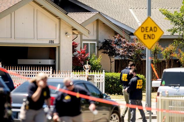 FBI agents approach a home, rear, being investigated in connection to a shooting at a Santa Clara Valley Transportation Authority (VTA) facility on Wednesday, May 26, 2021, in San Jose, Calif. A Santa Clara County sheriff's spokesman said a shooting at the rail yard left at least eight people, including the gunman, dead. (AP Photo/Noah Berger)