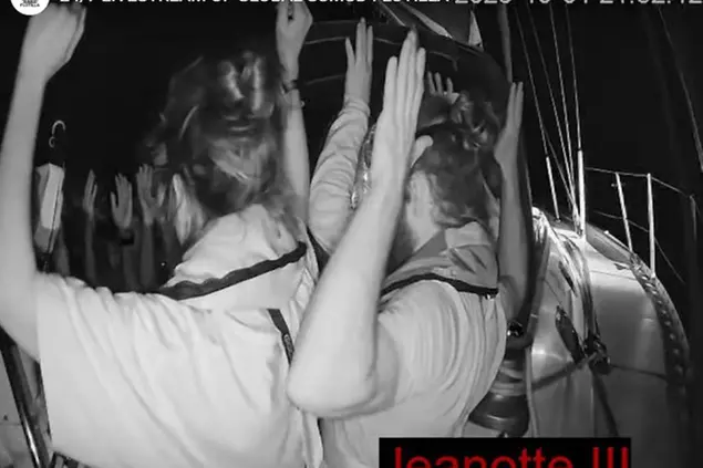 Un fermo immagine tratto dalla diretta streaming mostra alcuni attivisti della Flotilla con le mani alzate