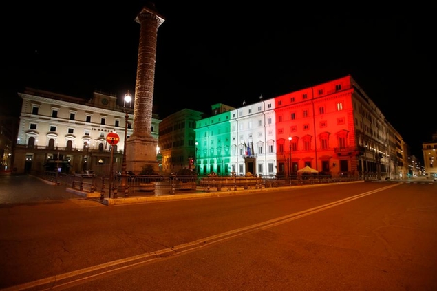 Palazzo Chigi Government office is lit with the color of the Italian flag, early Monday, Oct. 26, 2020. Since an 11 p.m.-5 a.m. curfew took effect Friday, people can only move around during those hours for reasons of work, health or necessity. (AP Photo/Alessandra Tarantino)