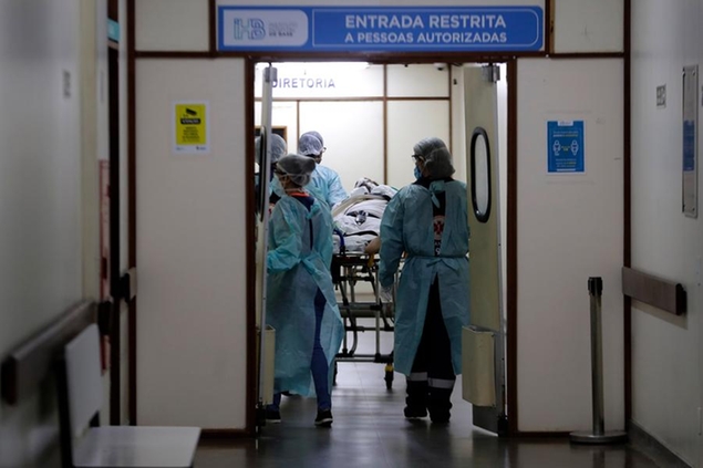 Healthcare workers bring a patient that was admitted suspected of suffering from COVID-19 to Base Public Hospital in Brasilia, Brazil, Wednesday, March 31, 2021. (AP Photo/Eraldo Peres)