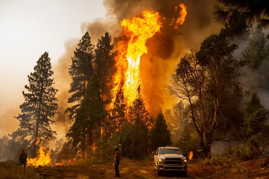 FILE - A firefighter monitors a backfire, flames lit by fire crews to burn off vegetation, while battling the Mosquito Fire in the Volcanoville community of El Dorado County, Calif., on Sept. 9, 2022. Drought and wildfire risks will remain elevated in the western states while warmer than average temperatures will greet the Southwest, Gulf Coast and East Coast this winter, federal weather officials said Thursday, Oct. 20. (AP Photo/Noah Berger, File)