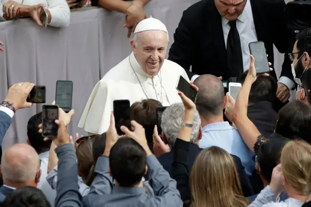 People hold up their phones and crowd towards Pope Francis as he arrives for his general audience, the first with faithful since February when the coronavirus outbreak broke out, at the San Damaso courtyard, at the Vatican, Wednesday, Sept. 2, 2020. (AP Photo/Andrew Medichini)