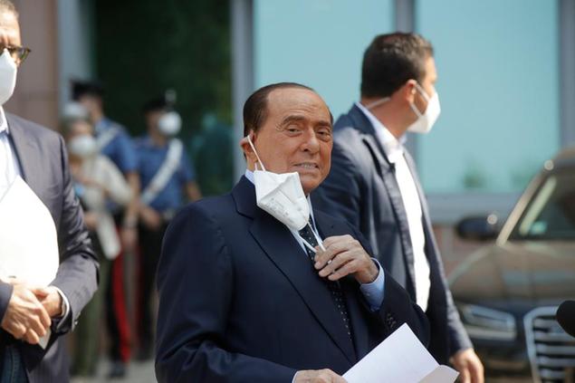 Italian former Premier Silvio Berlusconi adjusts his face mask as he leaves the San Raffaele hospital in Milan, Italy, Monday, Sept. 14, 2020. Berlusconi had been hospitalized as a precaution to monitor his coronavirus infection after testing positive for COVID-19. (AP Photo/Luca Bruno)