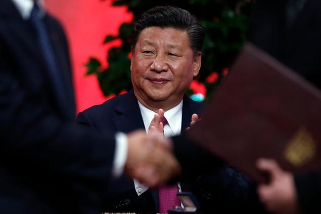 FILE- In this Tuesday, Nov. 22, 2016 file photo, China's President Xi Jinping applauds during the bilateral trade agreements signing ceremony at the Palacio de La Moneda in Santiago, Chile. China's President Xi Jinping will attend the World Economic Forum, that opens in the ski resort of Davos on Tuesday, Jan. 17, 2017, becoming the first Chinese head of state to do so. (AP Photo/Luis Hidalgo, File)