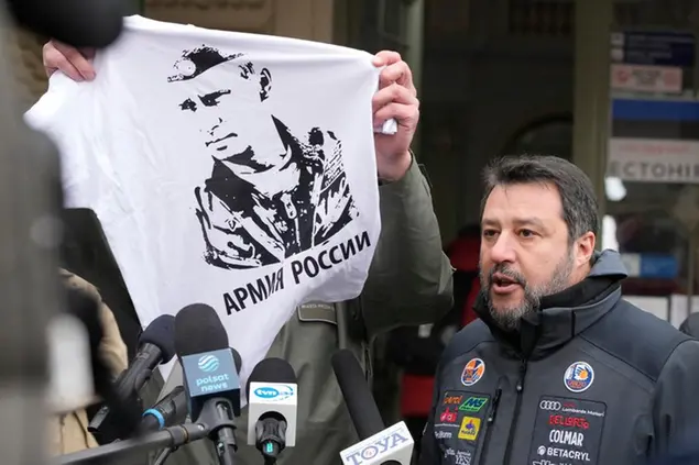 The Mayor of Przemysl, Wojciech Bakun, left, holds up a t-shirt with the likeness of Russian President Vladimir Putin and the words \\\\\\\"The Russian Army\\\\\\\" as Italy\\\\'s League Party leader, Matteo Salvini, right, speaks with journalists outside the train station in Przemysl, Poland, Tuesday, March 8, 2022. Matteo Salvini was confronted Tuesday by the mayor of Przemysl, Wojciech Bakun, during a news conference outside the train station where many of the more than 2 million refugees from war in Ukraine have come in recent days. (AP Photo/Czarek Sokolowski)