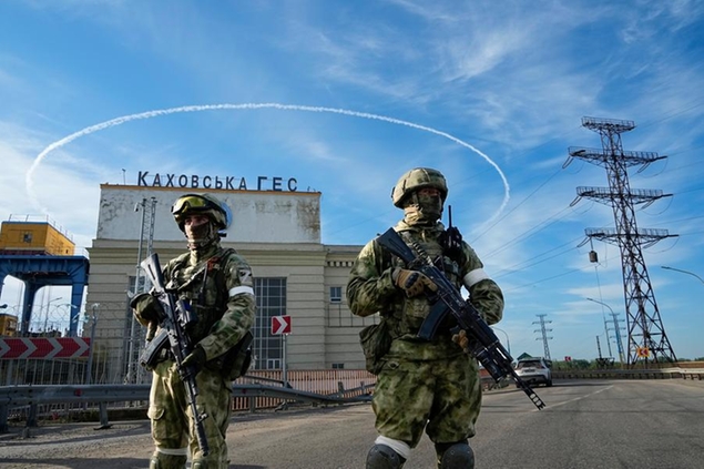 FILE - Russian troops guard an entrance of the Kakhovka Hydroelectric Station, a run-of-river power plant on the Dnieper River in Kherson region, south Ukraine, Friday, May 20, 2022. The Kherson region has been under control of the Russian forces since the early days of the Russian military action in Ukraine. This photo was taken during a trip organized by the Russian Ministry of Defense. (AP Photo, File)