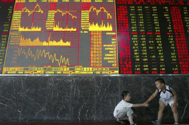 Two Chinese children play near an electronic board displaying stock prices at a stock exchange in Wuhan, central China's Hubei province Friday June 1 2007. Chinese stocks dropped Friday for a second time in three days following government efforts to cool a sizzling market that economists worry may be creating a price bubble. (AP Photo) ** CHINA OUT **