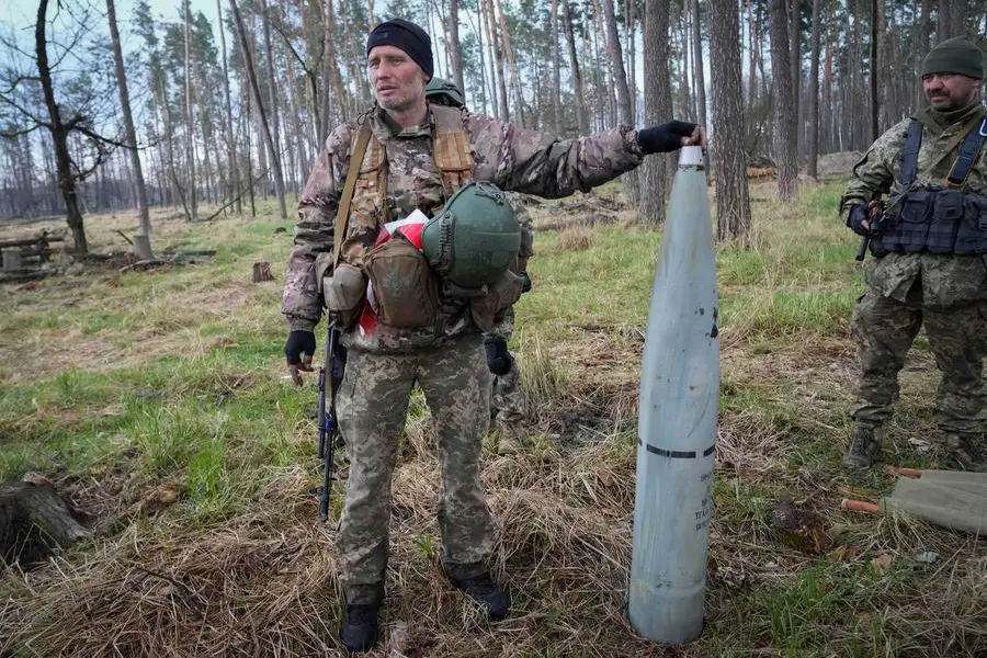 Ukrainian soldiers holds a fragment of a Russian multiple missile 'Uragan' after recent fights at the village of Berezivka, Ukraine, Thursday, April 21, 2022. (AP Photo/Efrem Lukatsky)