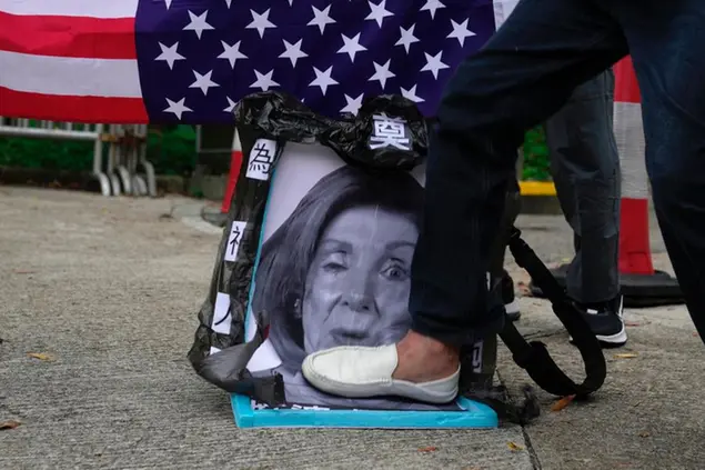Pro-China supporters step on a picture of U.S. House Speaker Nancy Pelosi during a protest outside the Consulate General of the United States in Hong Kong, Wednesday, Aug. 3, 2022. U.S. House Speaker Nancy Pelosi arrived in Taiwan late Tuesday, becoming the highest-ranking American official in 25 years to visit the self-ruled island claimed by China, which quickly announced that it would conduct military maneuvers in retaliation for her presence. (AP Photo/Kin Cheung)