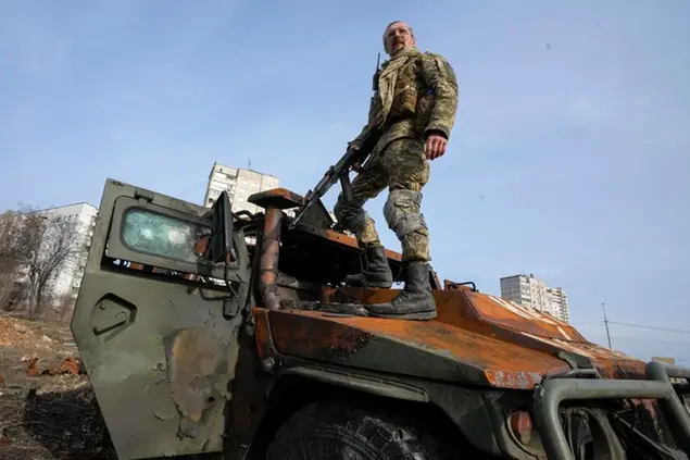 A Ukrainian soldier stands a top a destroyed Russian APC after recent battle in Kharkiv, Ukraine, Saturday, March 26, 2022. With Russia continuing to strike and encircle urban populations, from Chernihiv and Kharkiv in the north to Mariupol in the south, Ukrainian authorities said Saturday that they cannot trust statements from the Russian military Friday suggesting that the Kremlin planned to concentrate its remaining strength on wresting the entirety of Ukraine's eastern Donbas region from Ukrainian control. (AP Photo/Efrem Lukatsky)