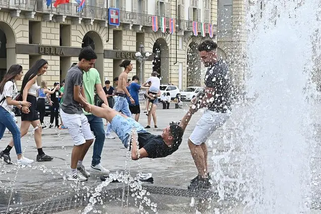 Gli studenti fanno festa e si bagnano nelle fontane di piazza Castello per la fine dell’anno scolastico a Torino (foto Ansa)