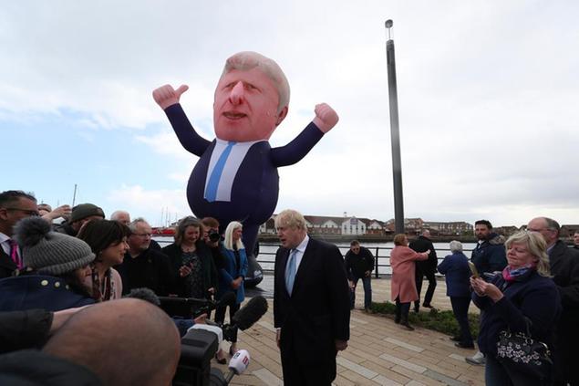 British Prime Minister Boris Johnson speaks to the media next to a large inflatable of him, after Conservative Party candidate Jill Mortimer won the Hartlepool by-election, at Hartlepool Marina, in Hartlepool, north east England, Friday, May 7, 2021. Britain's governing Conservative Party made further inroads in the north of England on Friday, winning a by-election in the post-industrial town of Hartlepool for a parliamentary seat that the main opposition Labour Party had held since its creation in 1974. (AP Photo/Scott Heppell)