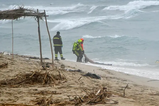 Rescuers recover a body at a beach near Cutro, southern Italy, after a migrant boat broke apart in rough seas on Sunday, Feb. 26, 2023. Rescue officials say an undetermined number of migrants have died and dozens have been rescued after their boat broke apart off southern Italy. (AP Photo/Giuseppe Pipita)