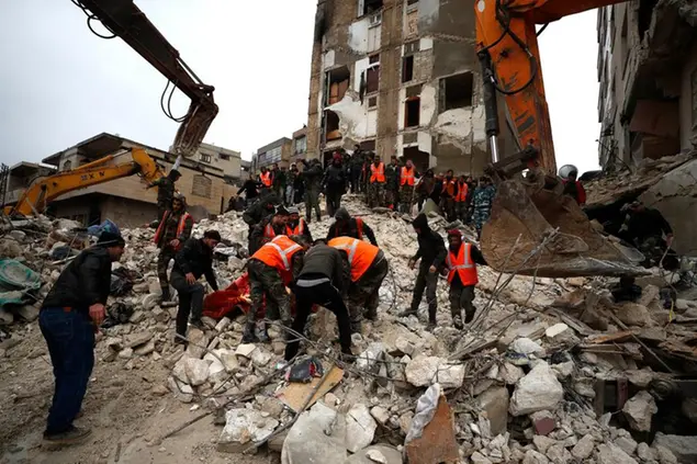 Civil defense workers and security forces search through the wreckage of collapsed buildings in Hama, Syria, Monday, Feb. 6, 2023. A powerful earthquake has caused significant damage in southeast Turkey and Syria and many casualties are feared. Damage was reported across several Turkish provinces, and rescue teams were being sent from around the country. (AP Photo/Omar Sanadiki)