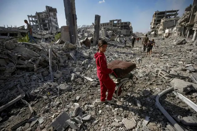 Una bambina palestinese cammina sulle rovine provocate dagli attacchi di guerra