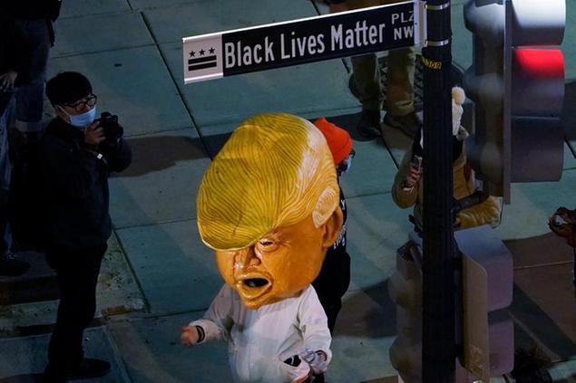 A person in a President Donald Trump costume joins people in Black Lives Matter Plaza near the White House in Washington, Tuesday, Nov. 3, 2020, on Election Day. (AP Photo/Susan Walsh)
