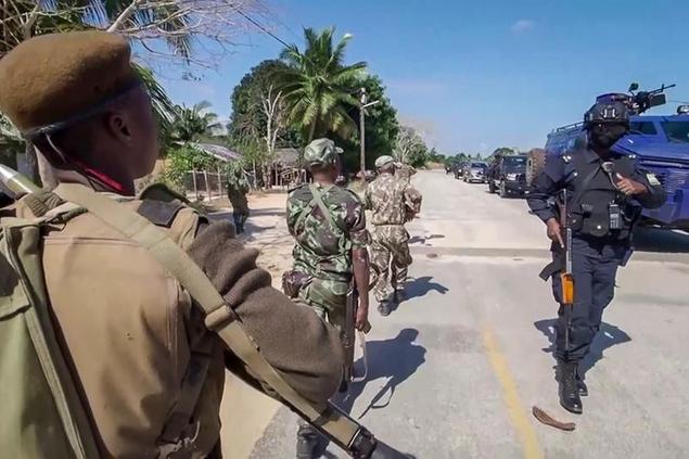 In this image made from video, a Rwandan policeman, right, and Mozambican military, left, patrol near the Amarula Palma hotel in Palma, Cabo Delgado province, Mozambique Sunday, Aug. 15, 2021. Rwanda's troops have rapidly helped Mozambique's armed forces achieve victories against Islamic extremists, who have created a humanitarian emergency in northern Cabo Delgado province and surrounding areas. (AP Photo/Marc Hoogsteyns)