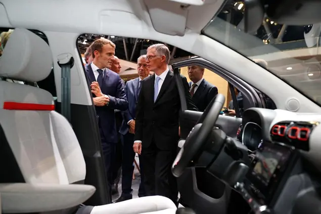 (Emmanuel Macron con Carlos Tavares, amministratore delegato di Stellantis. Foto AP)