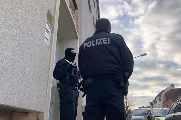 Police officers are standing outside an apartment building during a search in Osnabrueck, Germany, Friday, Nov. 6, 2020. German police have raided the homes and businesses of four men linked to the Islamic State sympathizer who carried out a deadly attack in Vienna this week. Federal police said Friday that officers, including members of the anti-terrorism unit GSG9, searched premises in Osnabrueck, Kassel and Pinneberg county. (Festim Beqiri/TV7News/dpa via AP)