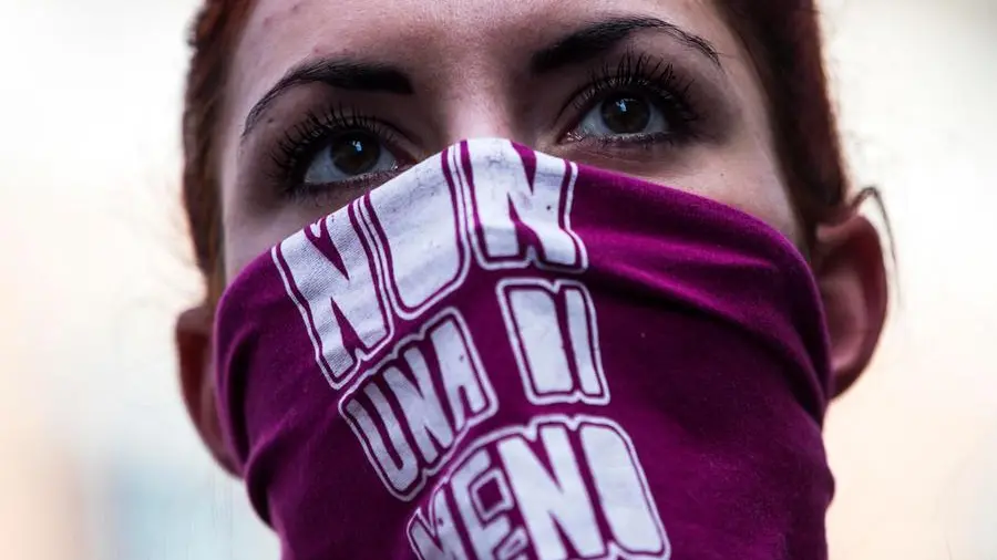 Manifestazione contro la violenza maschile, donne e attivisti si riuniscono in piazza, scritte e striscioni con il simbolo del movimento transfemminista