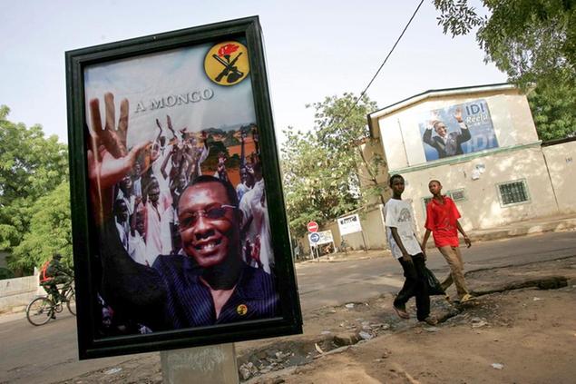 FILE - In this Tuesday, May 2, 2006 file photo, boys walk past posters of Chadian President Idriss Deby Itno ahead of the presidential election in the capital, N'djamena, Chad. Deby, who ruled the central African nation for more than three decades, was killed on the battlefield Tuesday, April 20, 2021 in a fight against rebels, the military announced on national television and radio. (AP Photo/Karel Prinsloo, File)