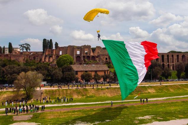 A parachutist with a large Italian flag is about to land in the Circus Maximum, the ancient Roman chariot-racing stadium and mass entertainment venue, in Rome, on occasion of celebrations for the foundation of the city, Wednesday, April 21, 2021. (AP Photo/Andrew Medichini)
