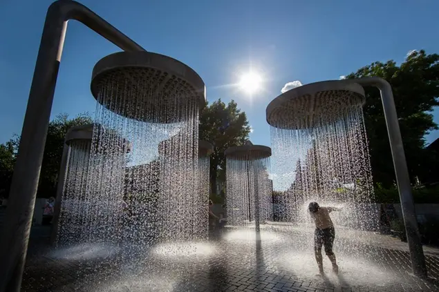 FILE - A boy cools off in a public fountain in Vilnius, Lithuania, June 26, 2022. This past year has seen a horrific flood that submerged one-third of Pakistan, one of the three costliest U.S. hurricanes on record, devastating droughts in Europe and China, a drought-triggered famine in Africa and deadly heat waves all over. (AP Photo/Mindaugas Kulbis, File)