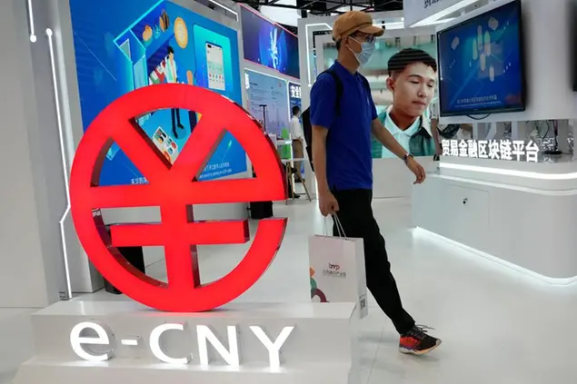 A visitor passes by a logo for the e-CNY, a digital version of the Chinese Yuan\\u00A0(AP Photo/Ng Han Guan)