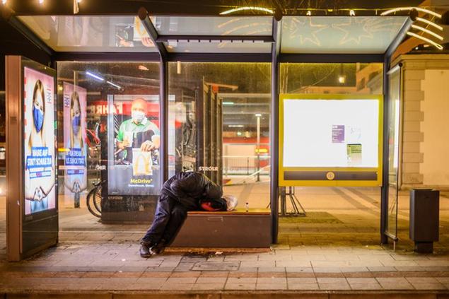 26 November 2020, Hessen, Frankfurt/Main: A homeless man sleeping in a bus stop. The refrigerated bus of the Frankfurt Verein f'r soziale Heimst'tten (Association for Social Homes) is on the road for homeless people in the city area during the cold season between 9:30 pm and 5:00 am. It offers transport to an overnight shelter, blankets, sleeping bags and warm tea. Photo by: Andreas Arnold/picture-alliance/dpa/AP Images