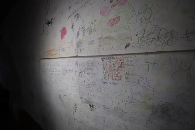 I disegni dei bambini sui muri di un seminterrato nel villaggio di Yahidne, in Ucraina (AP)