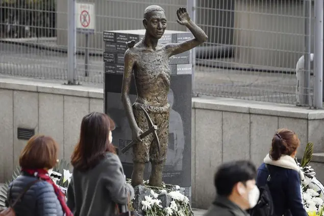 People pass by a statue symbolizing forced Korean workers, in Seoul Monday, March 6, 2023. South Korea says it’ll raise local civilian funds to compensate Koreans who won damages in lawsuits against Japanese companies that enslaved them during World War II. (Kyodo News via AP)