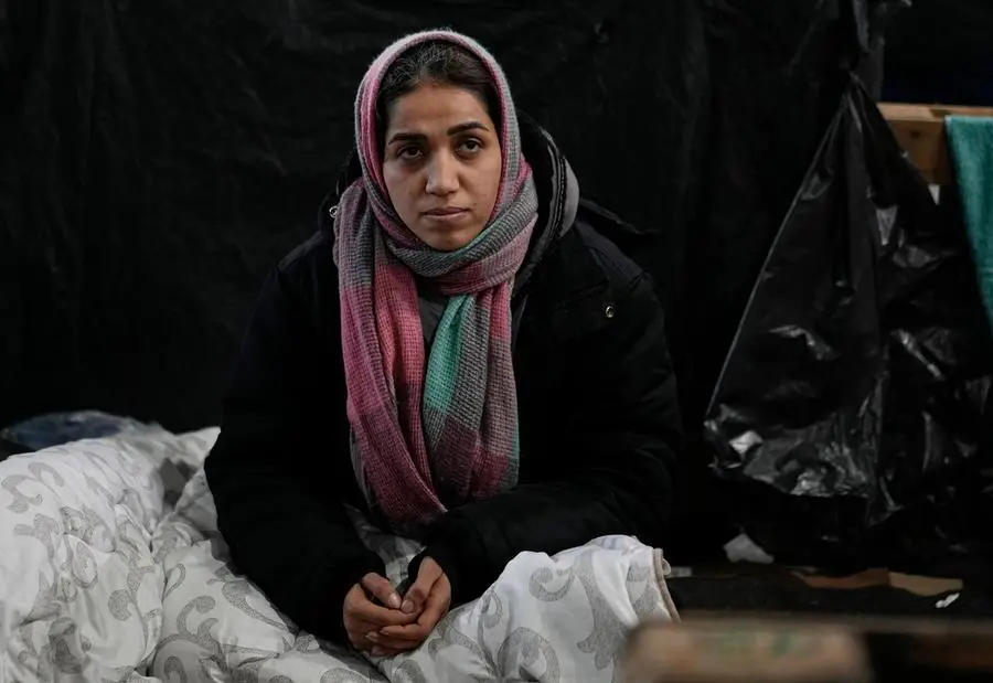 Una donna che vorrebbe migrare si trova bloccata in un centro al confine fra la Bielorussia e la Polonia. La foto è stata scattata il 23 dicembre (AP Photo/Pavel Golovkin)