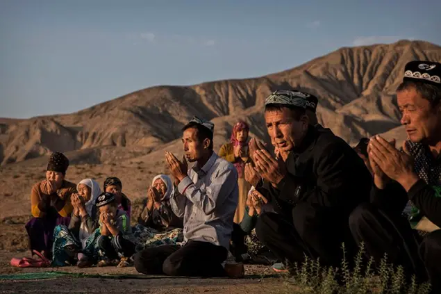 TURPAN, CHINA - SEPTEMBER 12: (CHINA OUT) A Uyghur family pray at the grave of a loved one on the morning of the Corban Festival on September 12, 2016 at a local shrine and cemetery in Turpan County, in the far western Xinjiang province, China. The Corban festival, known to Muslims worldwide as Eid al-Adha or 'feast of the sacrifice', is celebrated by ethnic Uyghurs across Xinjiang, the far-western region of China bordering Central Asia that is home to roughly half of the country's 23 million Muslims. The festival, considered the most important of the year, involves religious rites and visits to the graves of relatives, as well as sharing meals with family. Although Islam is a 'recognized' religion in the constitution of officially atheist China, ethnic Uyghurs are subjected to restrictions on religious and cultural practices that are imposed by China's Communist Party. Ethnic tensions have fueled violence that Chinese authorities point to as justification for the restrictions. (Photo by Kevin Frayer/Getty Images)