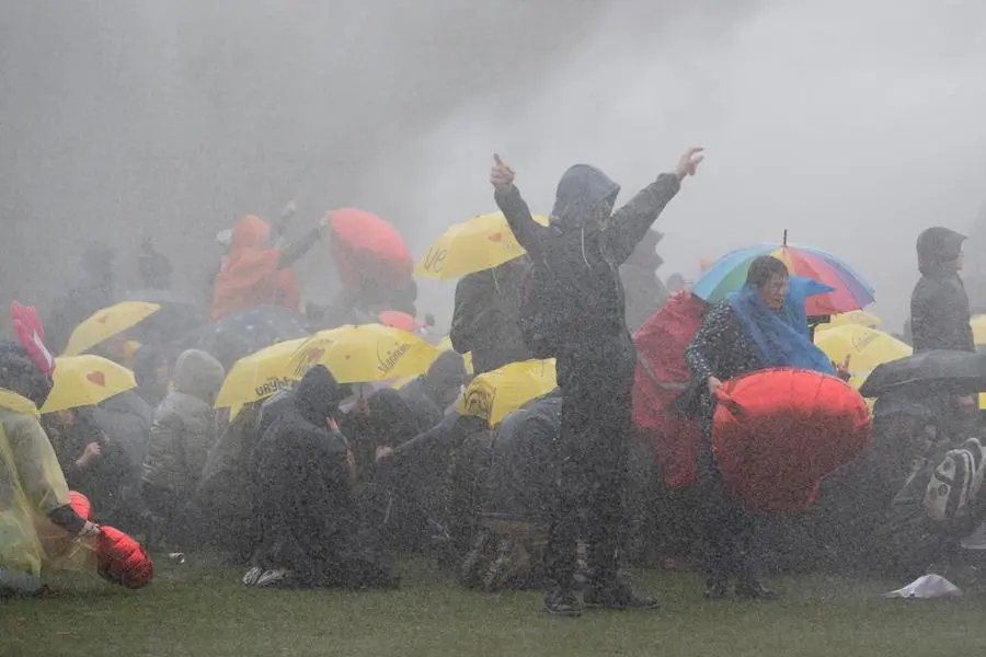 (Proteste contro le restrizioni, e cannoni ad acqua della polizia, il 28 marzo ad Amsterdam. Foto AP)
