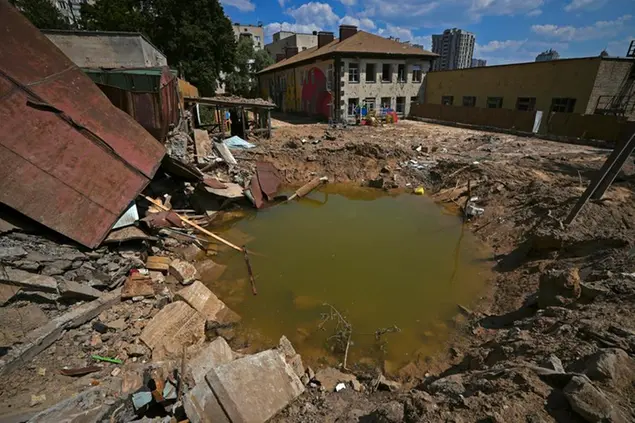 Photo taken in the Ukrainian capital of Kyiv on June 28, 2022, shows a crater filled with water from ruptured water pipes on the grounds of a kindergarten following Russian missile attacks on June 26. (Kyodo via AP Images) ==Kyodo