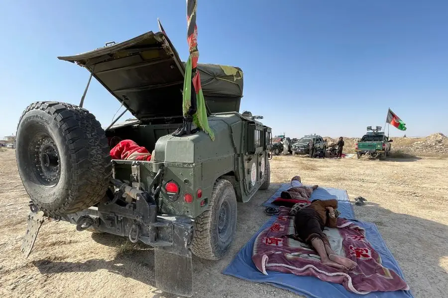 Afghan security personnel sleep by their vehicles at the army base in Kandahar during fighting between the Taliban and Afghan security personnel in the province, southwest of Kabul, Afghanistan, Friday, Aug. 13, 2021. (AP Photo/Sidiqullah Khan)
