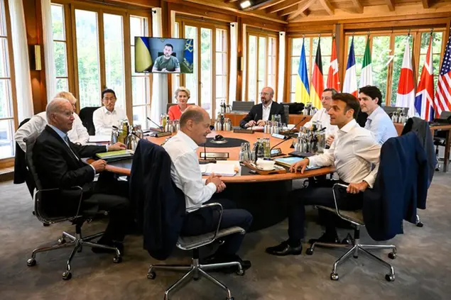 From front center clockwise, Germany's Chancellor Olaf Scholz, US President Joe Biden, Britain's Prime Minister Boris Johnson, Japan's Prime Minister Fumio Kishida, European Commission President Ursula von der Leyen, European Council President Charles Michel, Italy's Prime Minister Mario Draghi, Canada's Prime Minister Justin Trudeau and France's President Emmanuel Macron have taken seat at a round table as Ukraine's President Volodymyr Zelensky addresses the G7 leaders via video link during their working session at Castle Elmau in Kruen, near Garmisch-Partenkirchen, Germany, on Monday, June 27, 2022. The Group of Seven leading economic powers are meeting in Germany for their annual gathering Sunday through Tuesday. (Tobias Schwarz/Pool Photo via AP)