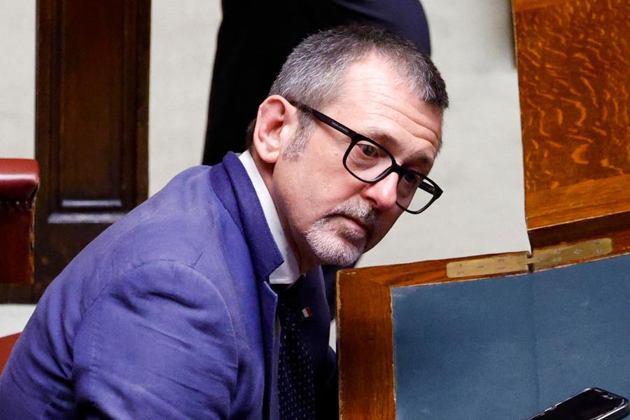 Aula della Camera dei deputati con banchi vuoti, tavolo della giunta, scrivania presidenziale illuminata