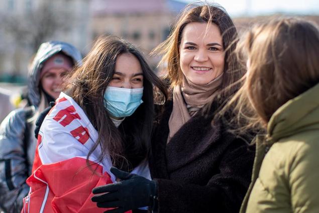 Belarus opposition leader Sviatlana Tsikhanouskaya, right, poses for photos with demonstrators during a protest demanding freedom for political prisoners in Belarus at the Cathedral Square in Vilnius, Lithuania, Saturday, March 20, 2021. (AP Photo/Mindaugas Kulbis)