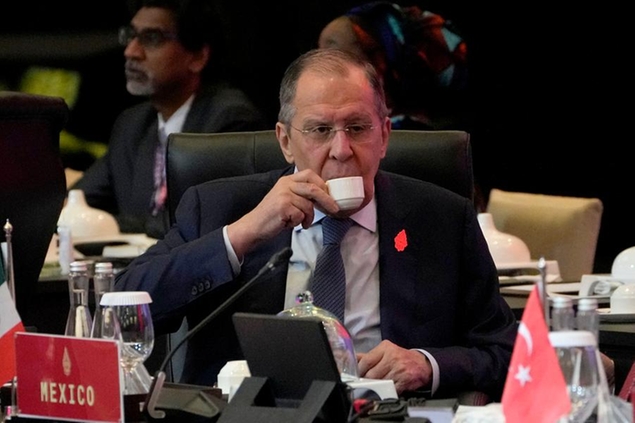 Russian Foreign Minister Sergey Lavrov sips his drink prior to the start of the opening session of the G20 Foreign Ministers' Meeting in Nusa Dua, Bali, Indonesia, Friday, July 8, 2022. (AP Photo/Dita Alangkara, Pool)