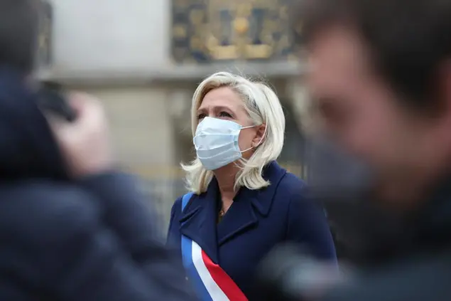 French far-right leader Marine le Pen, wearing a protective face mask, stands at the statue of Joan of Arc during a ceremony Friday, May 1, 2020 in Paris. Far-right militants usually gather at the statue for their annual May Day march. (AP Photo/Thibault Camus)